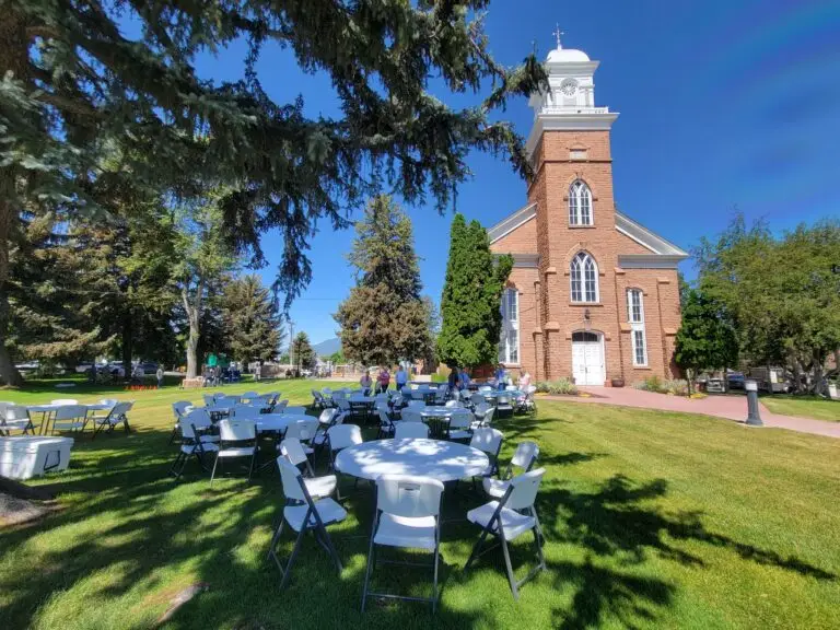 Heber City Tabernacle building with tables and chairs under a large tree
